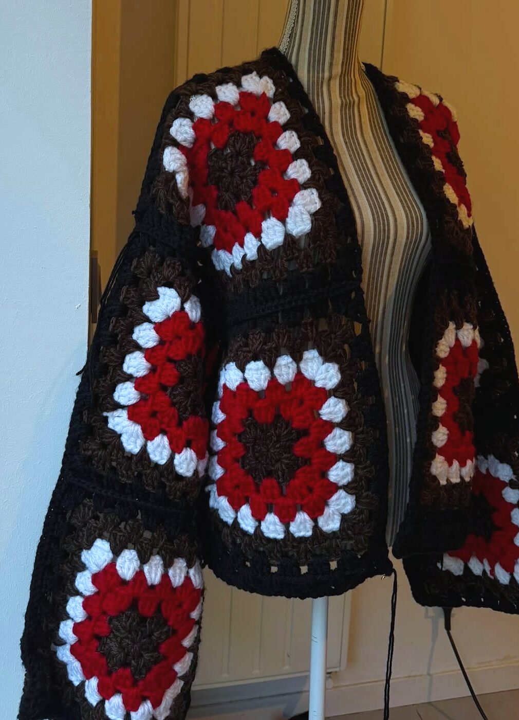 Kimono en crochet granny square brun, rouge et écru, présenté sur mannequin