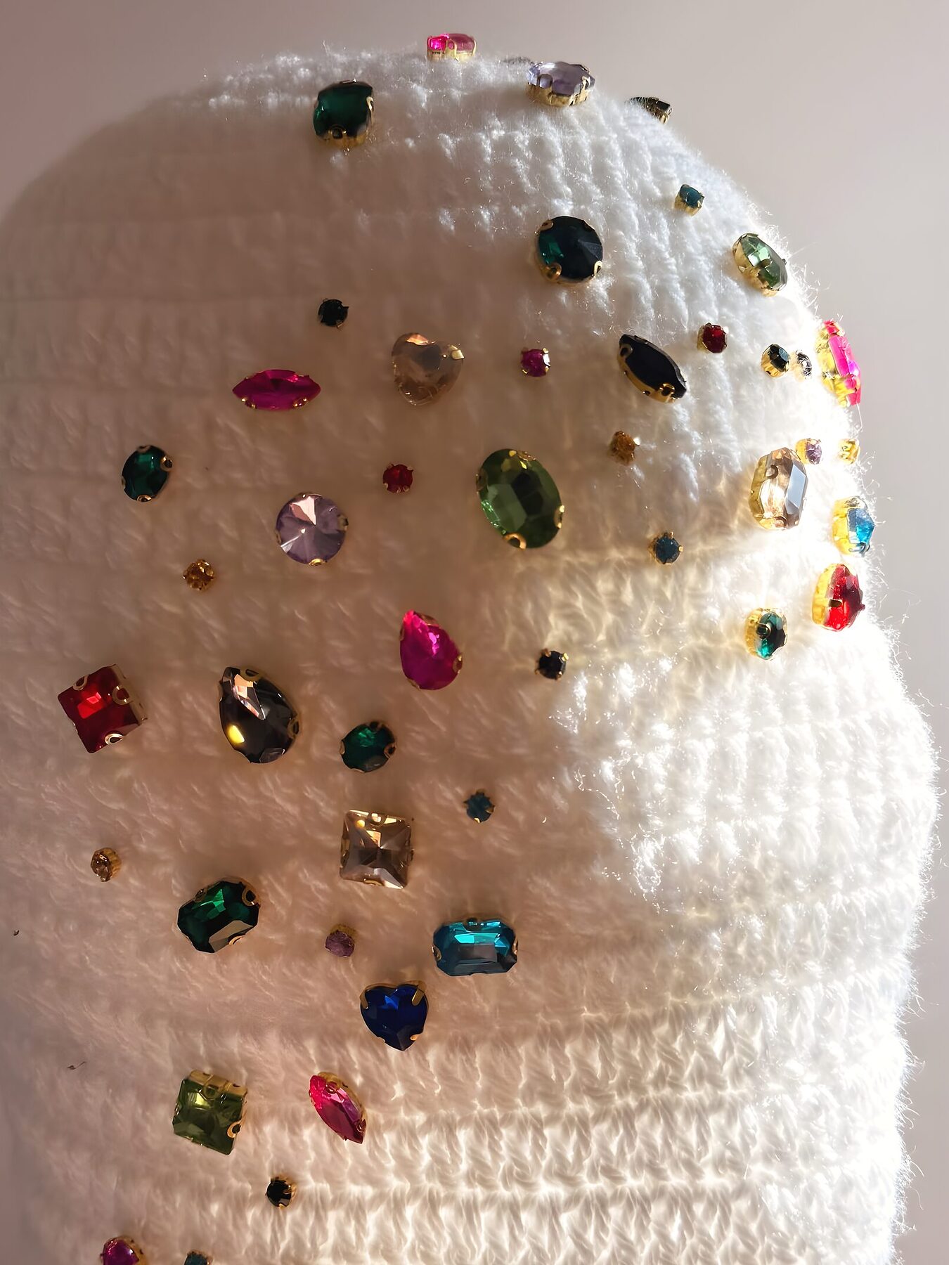 Bonnet Aura Jewel — crochet blanc serti de perles et de pierres colorées, en lumière douce