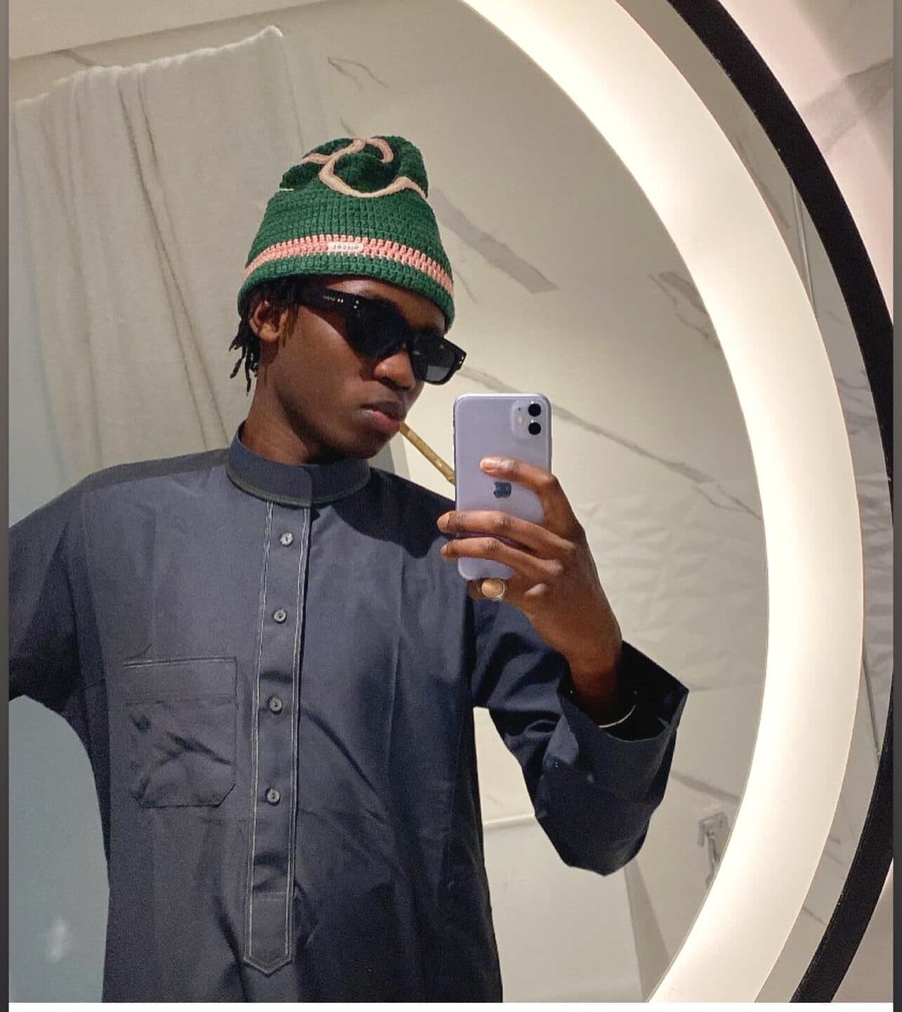 @papyfara porte un bonnet RAMÉA vert à bande pêche, selfie miroir circulaire