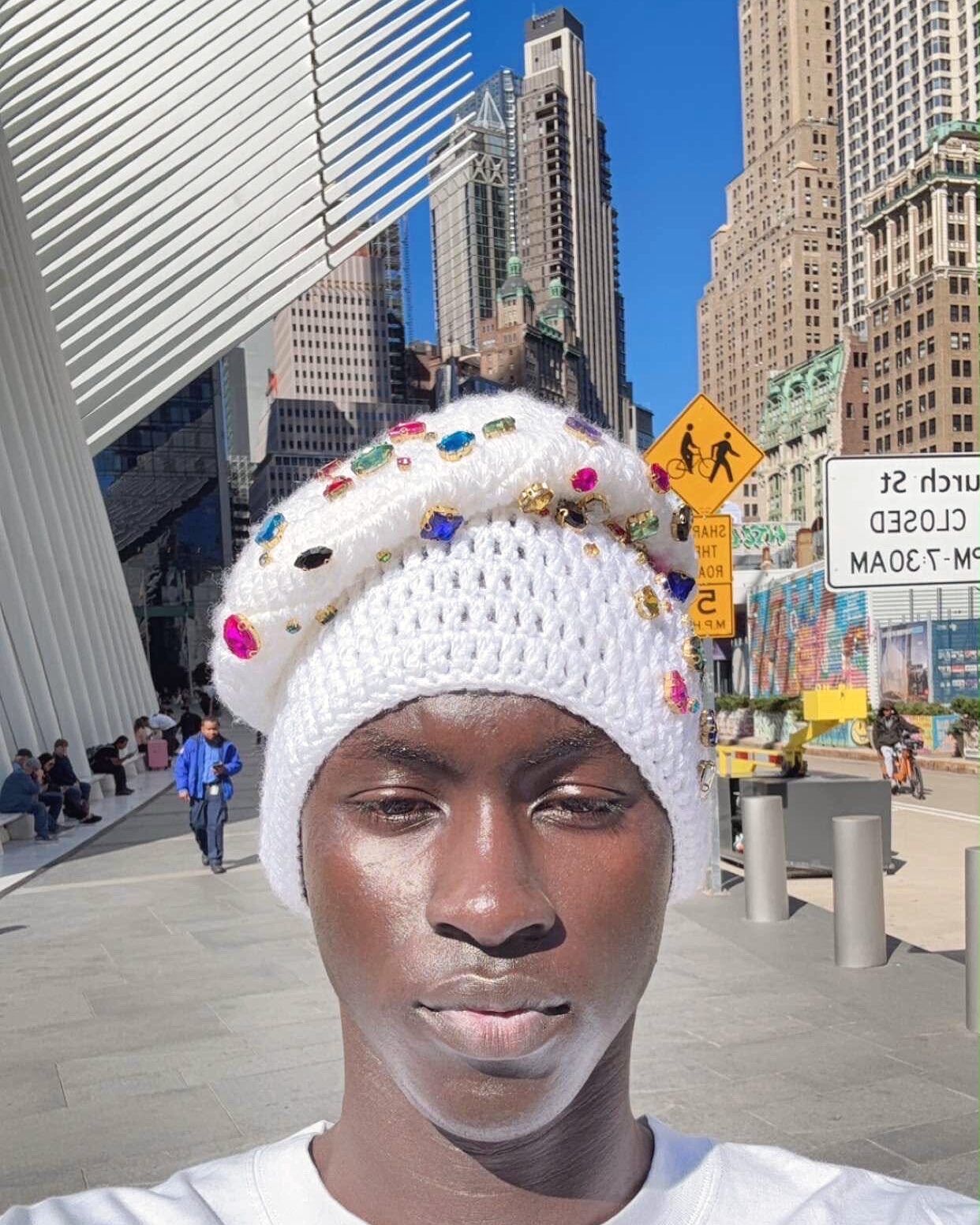 Bonnet Aura Jewel en crochet blanc serti de perles colorées, porté dans une rue de New York en plein soleil