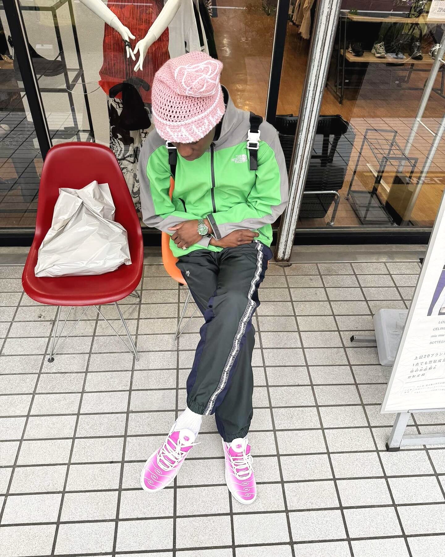 Silhouette streetwear RAMÉA — bonnet rose personnalisé et veste verte, rue de Tokyo